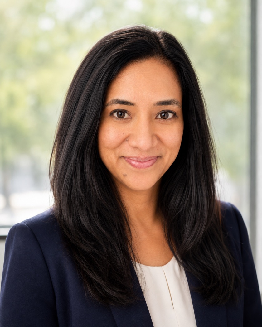 Ragini Domenichini, licensed mortgage agent, smiling warmly in a navy blazer by a bright window